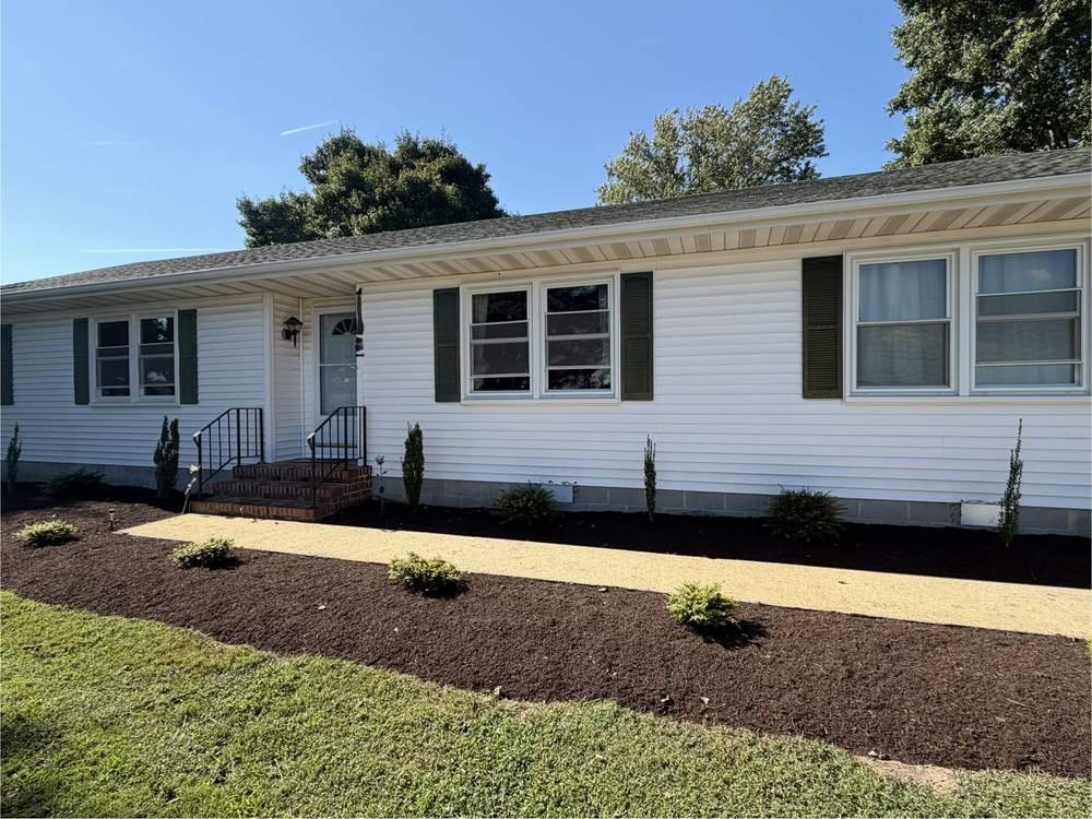 Front garden bed with fresh mulch and new shrubs after renovation